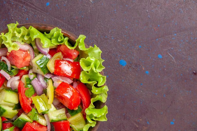 Vue rapprochée de la délicieuse salade de légumes en tranches avec des ingrédients frais sur un espace sombre