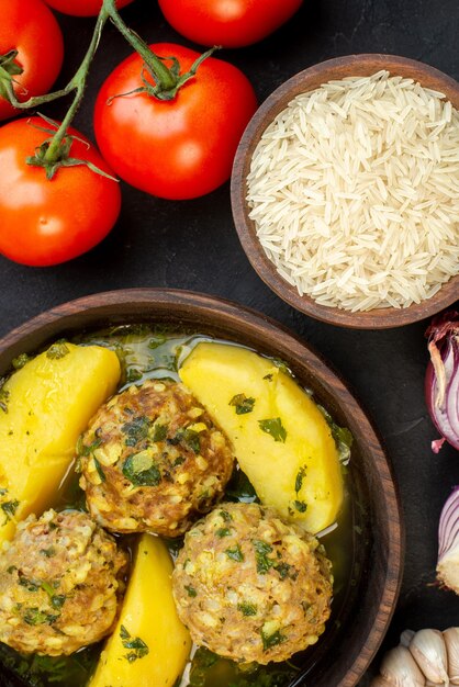 Vue rapprochée de délicieux repas de boulettes de viande tomates de riz vert avec des tiges sur fond noir