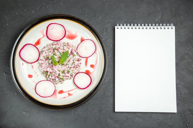 Vue rapprochée de dessus une assiette de plat appétissant d'herbes de radis et de sauce cahier blanc