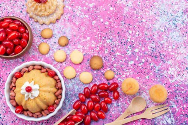 Vue rapprochée de dessus délicieux gâteau simple avec de la crème et des cacahuètes fraîches cornouiller rouge sur un bureau lumineux, biscuit gâteau aux noix sucrées berry