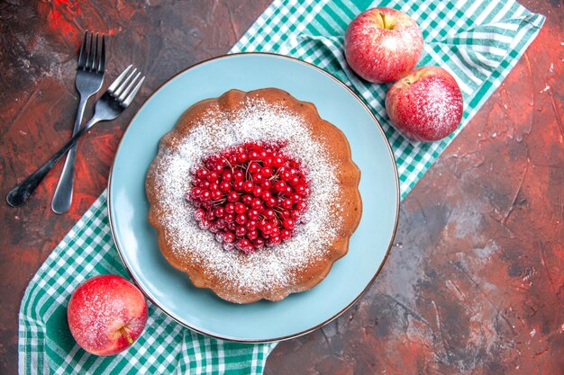 Vue rapprochée de dessus un gâteau un gâteau appétissant pommes rouges sur les fourchettes de nappe blanc-bleu