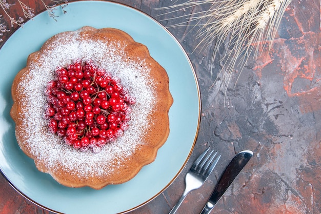 Vue rapprochée de dessus un gâteau un gâteau aux groseilles rouges sur la plaque oreilles de blé couteau et fourchette