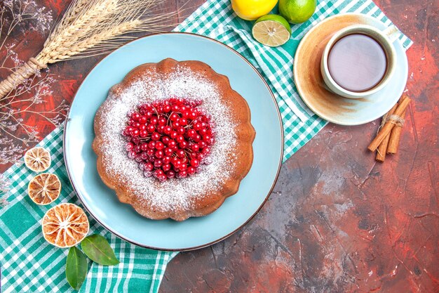 Vue rapprochée de dessus un gâteau une tasse de thé des bâtons de cannelle un gâteau d'agrumes sur la nappe