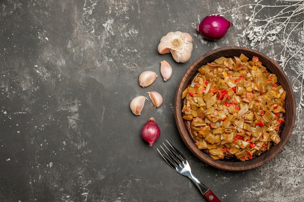 Vue Rapprochée De Dessus Haricots Verts Avec Tomates Assiette En Bois De Haricots Verts Et Tomates à Côté De L'ail Oignon Et Fourchette Sur La Table