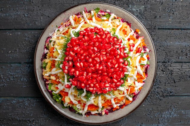 Vue rapprochée de dessus Salade de Noël Salade de Noël avec pommes de terre carottes betteraves sur la plaque blanche sur la table