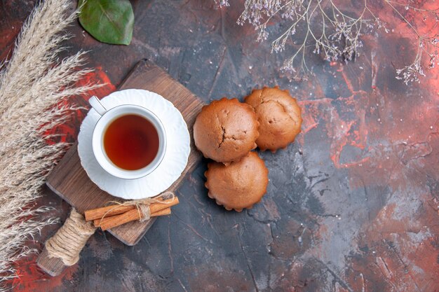 Vue rapprochée de dessus une tasse de thé une tasse de thé des bâtons de cannelle sur le plateau d'agrumes