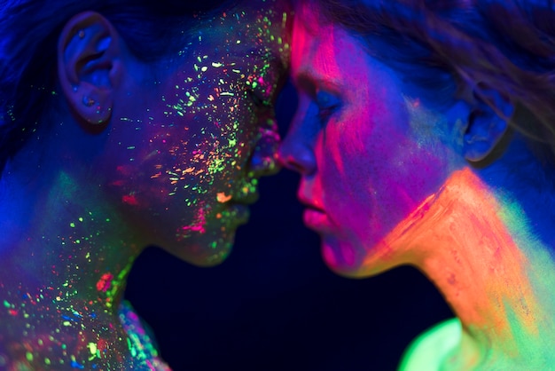 Vue rapprochée de deux personnes avec du maquillage fluorescent