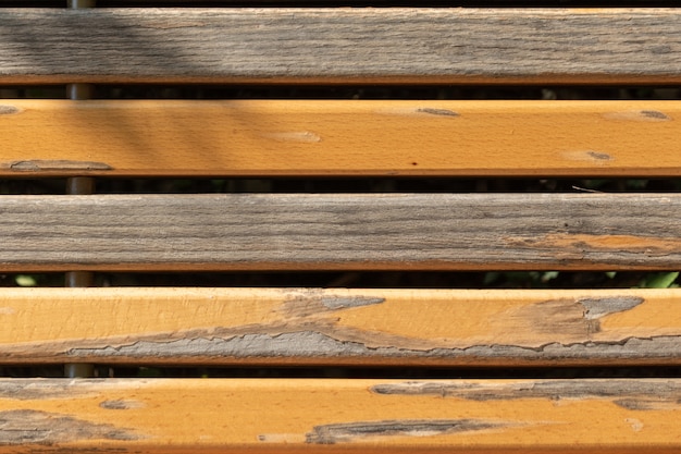 Vue rapprochée du banc avec peinture partiellement écaillée sur les planches