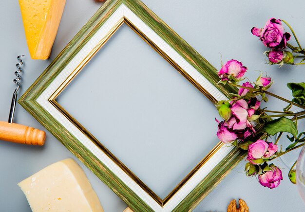 Vue rapprochée du cadre avec tire-bouchon à fromage et fleurs autour sur blanc avec copie espace