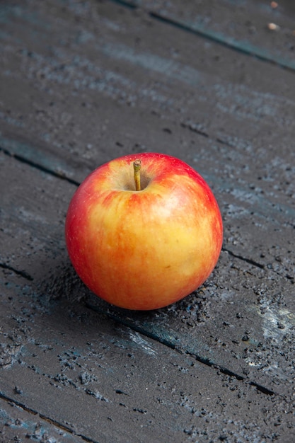 Photo gratuite vue rapprochée du côté pomme jaune-rougeâtre sur une table en bois gris