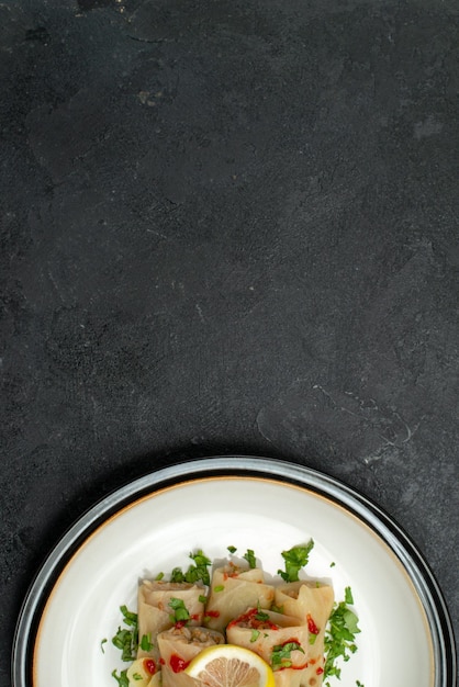 Vue Rapprochée Du Haut De L'assiette D'un Plat Appétissant Plat Appétissant De Chou Farci Aux Herbes Citron Et Sauce Sur Une Assiette Blanche Sur Une Surface Noire