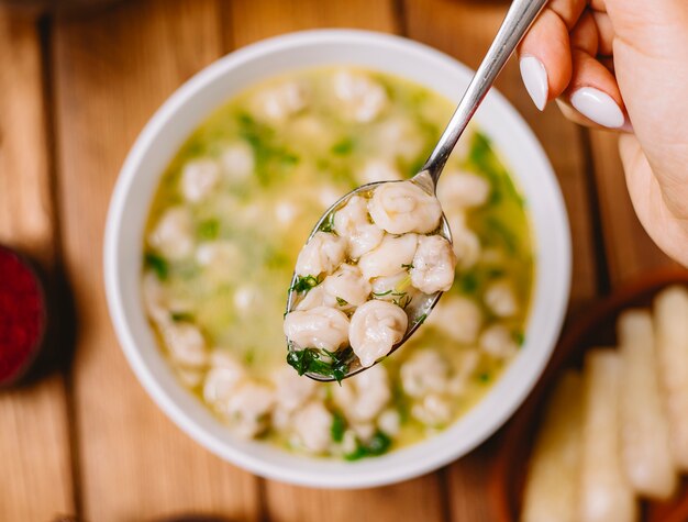 Vue rapprochée du haut de la soupe aux boulettes de dushbara servie avec des herbes et des épices séchées