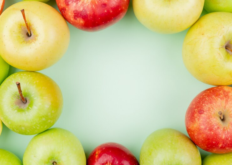 Photo gratuit vue rapprochée du modèle de pommes rouges vertes et jaunes entières sur fond vert avec espace copie