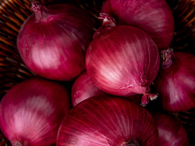 Photo gratuite vue rapprochée du panier d'oignons rouges