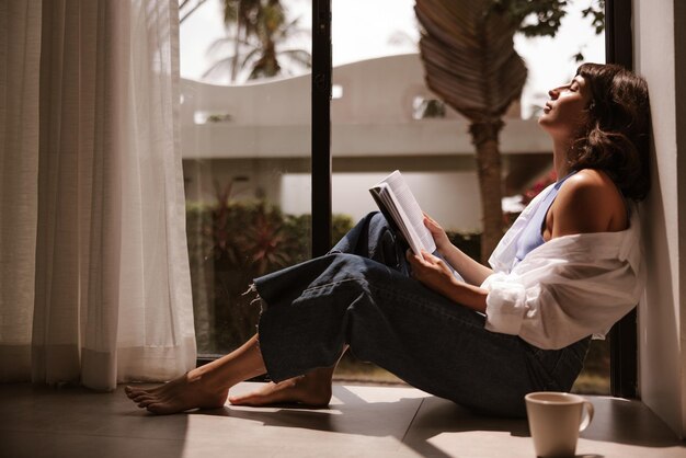 Vue rapprochée d'une femme mignonne avec un livre à la maison