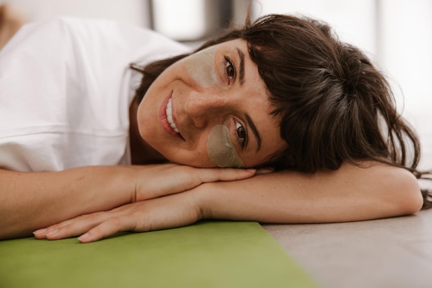 Vue rapprochée d'une femme souriante avec des patchs regarde la caméra