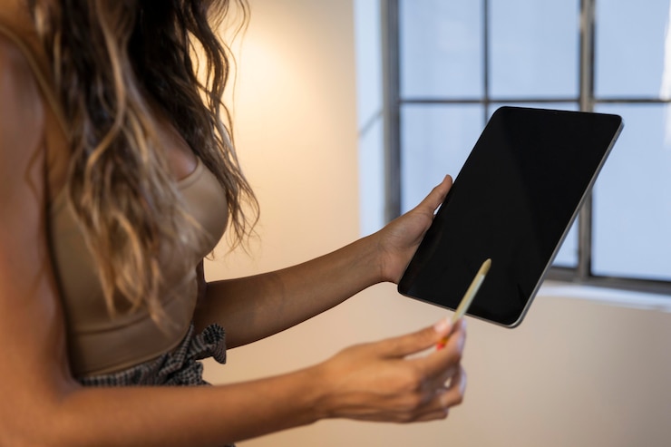 Photo gratuit vue rapprochée d'une femme avec un stylo tenant une tablette