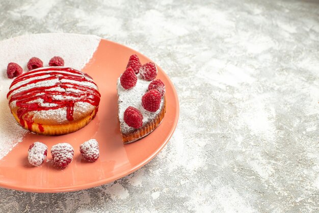 Vue rapprochée latérale du dessert sucré avec de la sauce dessus et des baies sur fond de marbre