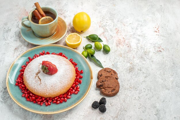 Vue rapprochée latérale du gâteau le gâteau appétissant avec des biscuits aux agrumes à la grenade sur la table