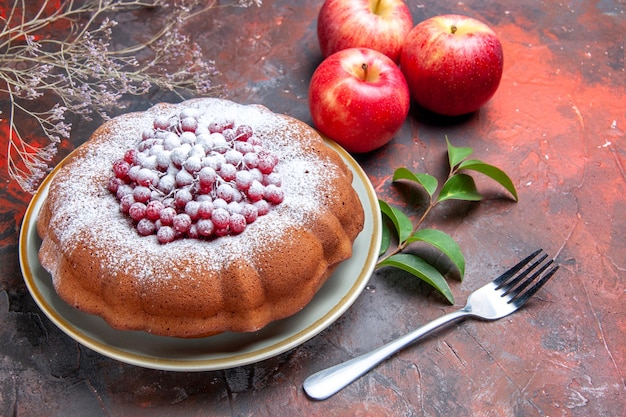 Vue rapprochée latérale du gâteau un gâteau avec des groseilles rouges et des pommes de fourchette à sucre feuilles des branches