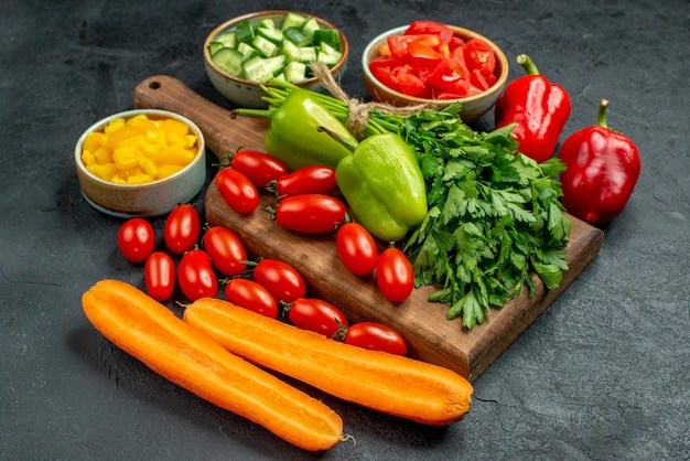 Vue rapprochée latérale du support d'assiette avec des légumes au-dessus et à proximité sur fond gris foncé