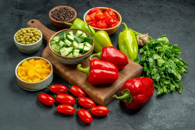 Vue rapprochée latérale du support d'assiette avec des légumes au-dessus et à proximité sur fond gris foncé