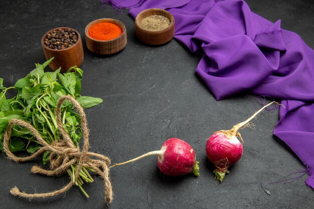 Vue rapprochée latérale épices épices colorées poivre noir radis herbes et la nappe violette