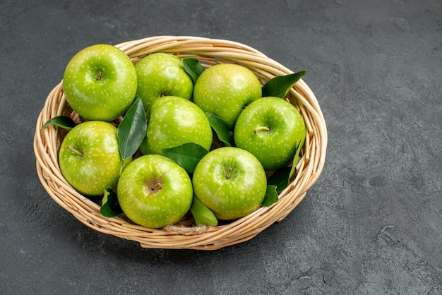 Vue rapprochée latérale des pommes vertes les huit pommes vertes appétissantes dans le panier en bois