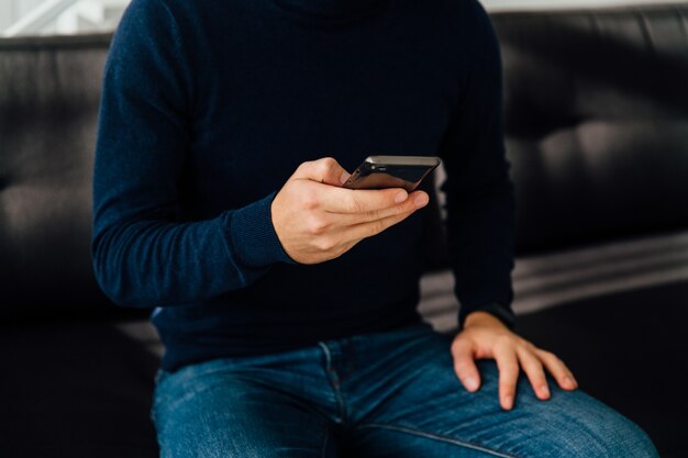 Vue rapprochée de la main masculine à l&#39;aide d&#39;un téléphone mobile.