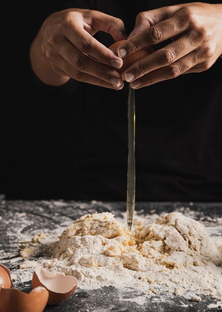 Photo gratuite vue rapprochée des mains séparant les oeufs dans la pâte