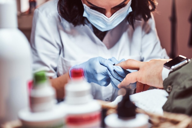 Vue rapprochée. Le maître esthéticien fait une procédure de manucure. Un homme recevant une manucure dans le salon de beauté