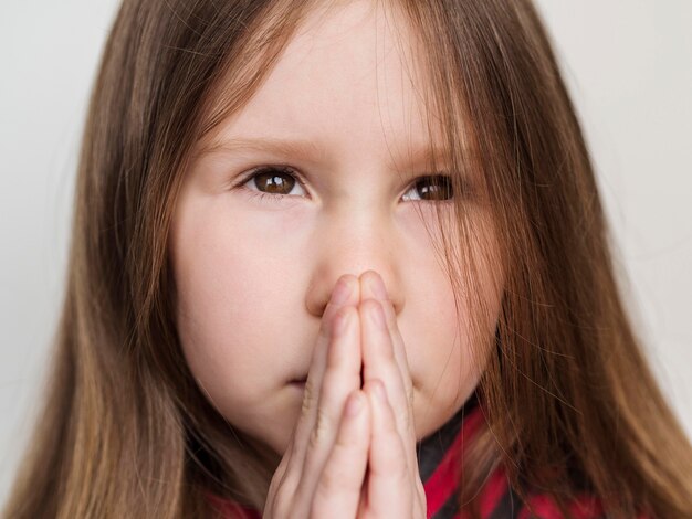 Vue rapprochée de la mignonne petite fille priant