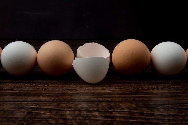 Vue rapprochée des oeufs et coquille d'oeuf sur la surface en bois et fond noir