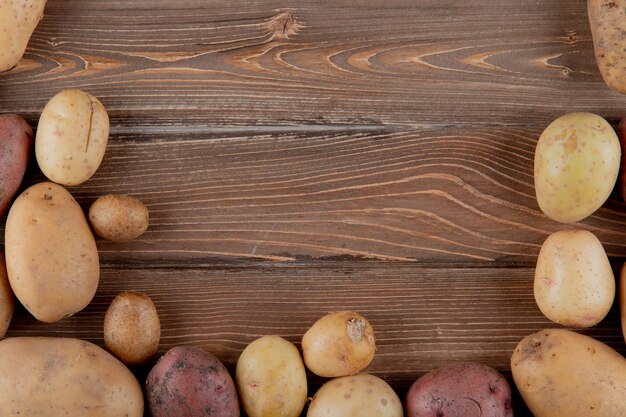 Vue rapprochée de pommes de terre entières sur fond de bois avec copie espace