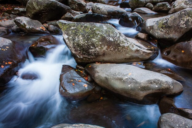 Vue rapprochée des rochers dans l'écoulement en cascade de la rivière par une journée froide