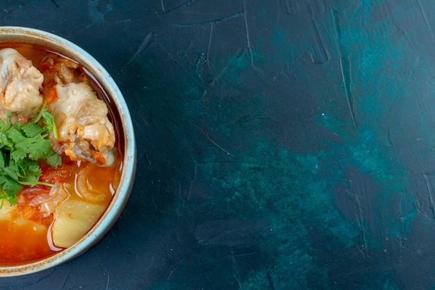 Photo gratuite vue rapprochée de la soupe au poulet avec du poulet et des verts à l'intérieur sur le fond bleu foncé soupe viande nourriture dîner