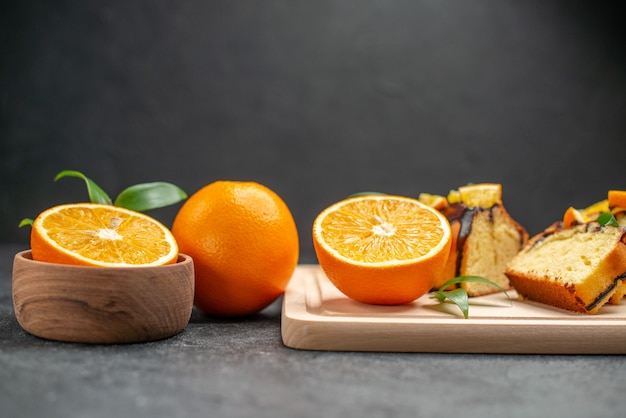 Photo gratuite vue rapprochée de tranches de citron frais et de tranches de gâteau hachées fraîchement cuites sur table sombre