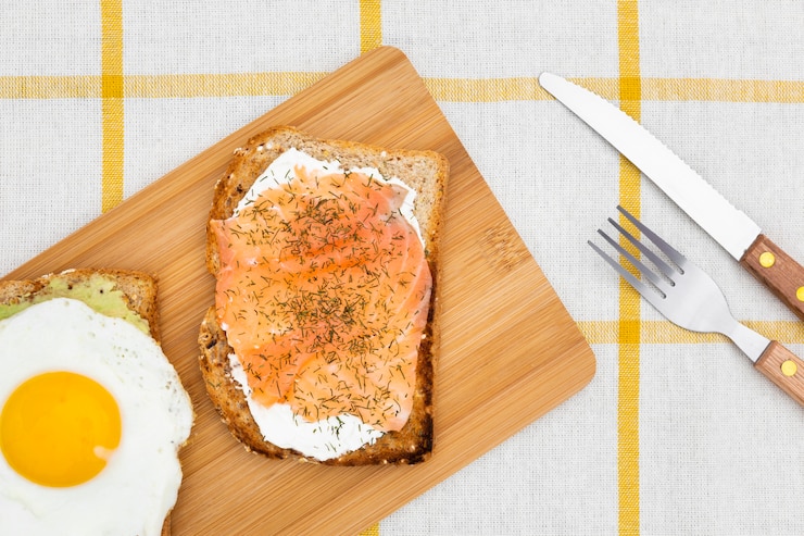 Photo gratuit vue supérieure de la planche à découper avec du pain grillé et des œufs sur le dessus