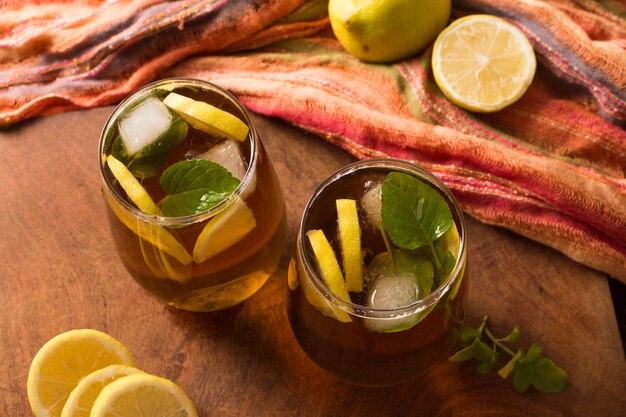 Une vue suré de thé au citron glacé et menthe laisse sur une table en bois