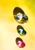 Photo gratuite une vue surélevée de blanc; vert; et diamant rose sur fond jaune