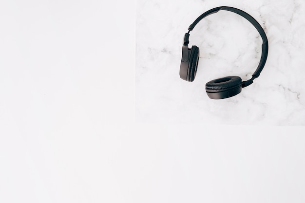 Photo gratuite une vue surélevée d'un casque noir sur un bureau sur fond blanc