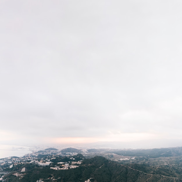 Une vue surélevée du paysage de montagne de campagne avec un ciel nuageux blanc