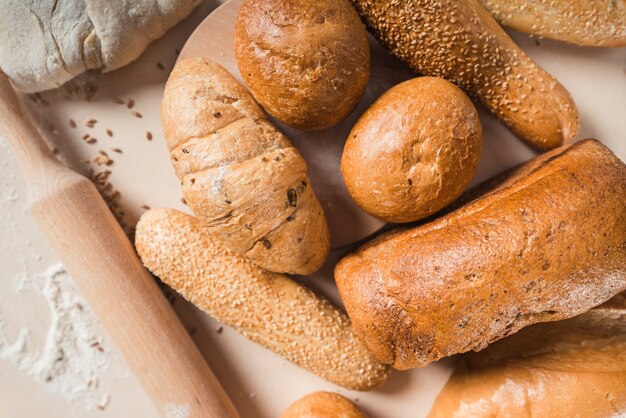 Vue surélevée de pains de forme variée et de rouleau à pâtisserie