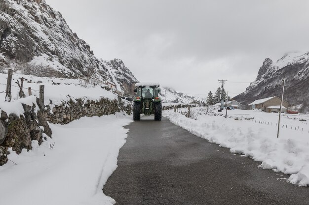 Vue d'un tracteur à neige dégageant la route après une tempête de neige
