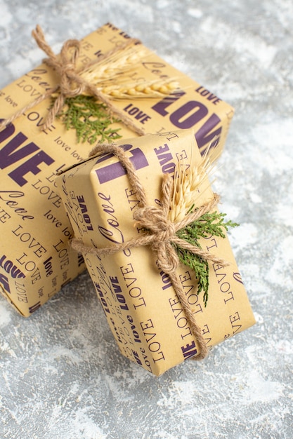 Vue verticale de beaux cadeaux emballés avec inscription d'amour sur la table de glace