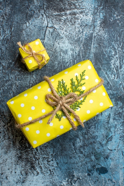 Vue verticale de belles boîtes-cadeaux de Noël jaunes empilées pour les membres de la famille sur fond sombre