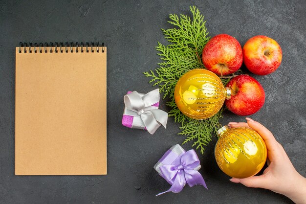 Vue verticale des cadeaux et accessoires de décoration de pommes fraîches biologiques naturelles et cahiers sur tableau noir