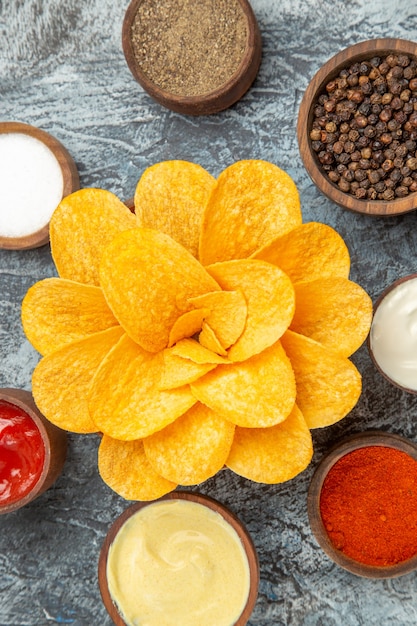 Photo gratuite vue verticale de chips maison décorées comme une fleur en forme dans un bol brun sur fond gris