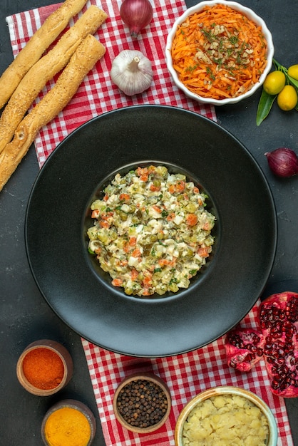 Vue verticale d'une délicieuse salade d'ail poivrons salade grenades kumquats avec tige sur fond sombre