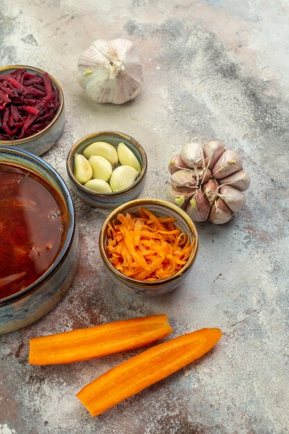 Vue verticale de la délicieuse soupe de bortsch ses ingrédients hachés et entiers sur un fond coloré